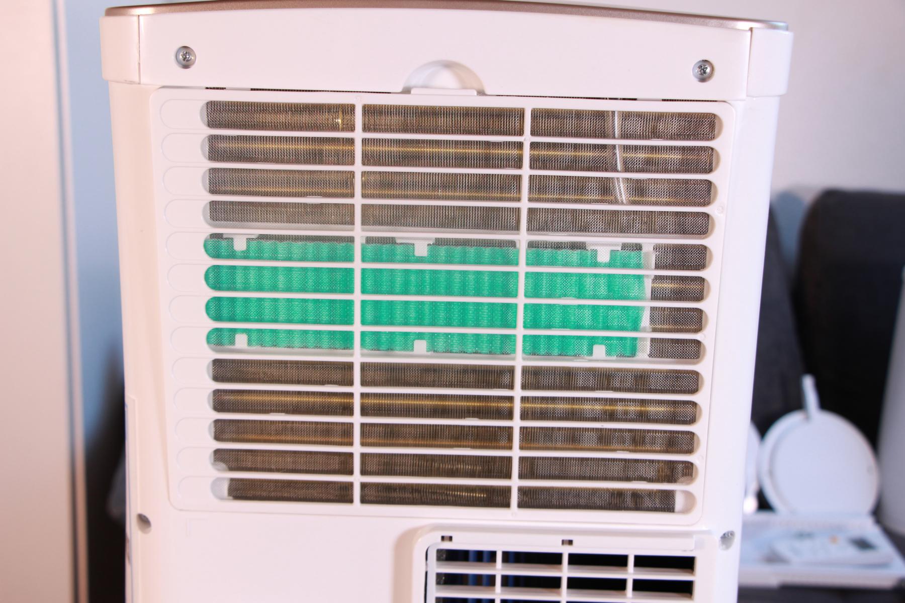 Leise mobile Klimaanlage wird im Test gezeigt und der Luftfilter wird ausgebaut. 